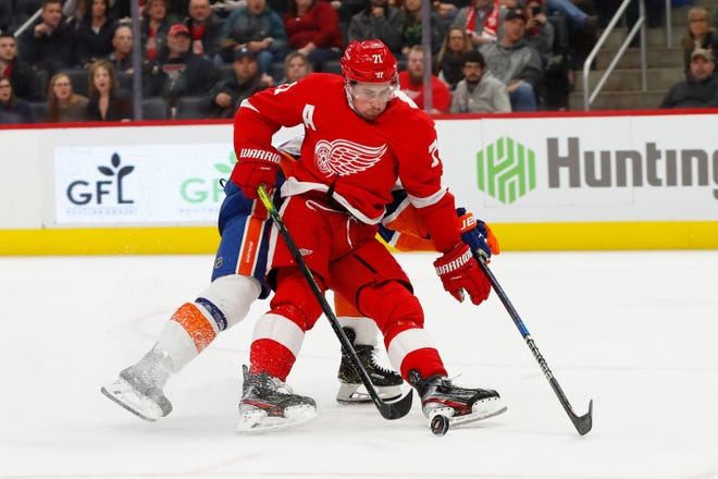 Detroit Red Wings center Dylan Larkin (71) protects the puck from New York Islanders defenseman Nick Leddy (2) in the second period of an NHL hockey game Monday, Dec. 2, 2019, in Detroit. (AP Photo/Paul Sancya)