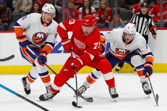 Detroit Red Wings left wing Adam Erne (73) skates past New York Islanders left wing Otto Koivula (21) and Ryan Pulock (6) in the second period.