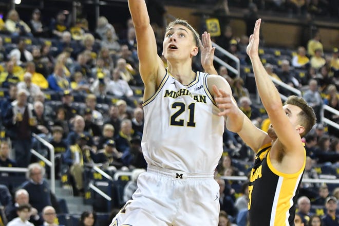 Michigan's Franz Wagner (21) goes to the basket past Iowa's Jack Nunge In the first half of a game at at Crisler Center, at in Ann Arbor, December 6, 2019.
