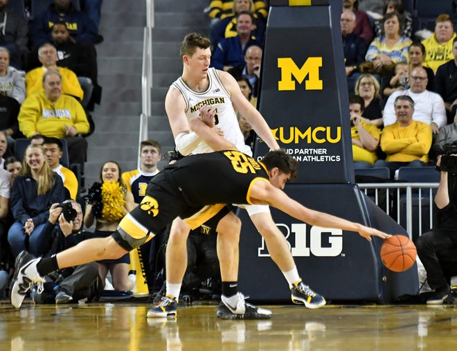 Iowa center Luka Garza (55) goes for the loose ball in front of Michigan center Jon Teske (15) in the first half.