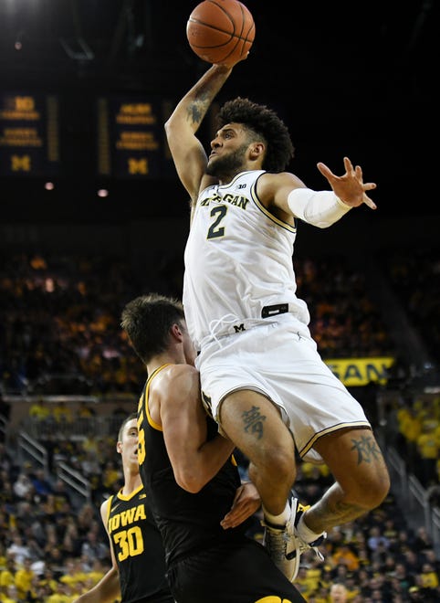 Michigan forward Isaiah Livers (2) goes up for a dunk over Iowa center Luka Garza (55) who is called for the foul in the second half.