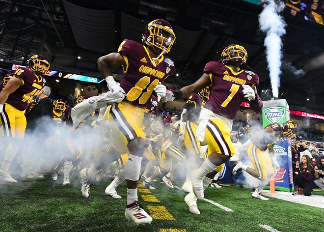 Central's Kalil Pimpleton and Michael Oliver lead the team onto the field for the 2019 MAC Championship game against Miami.