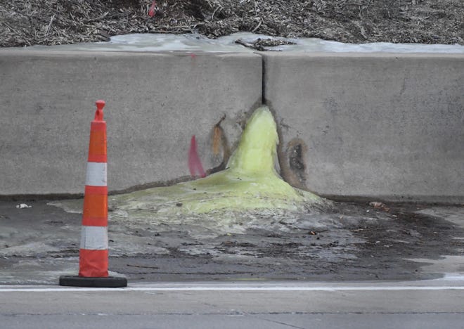 A green liquid seeps out a wall along the shoulder of the eastbound lanes of I-696 just west of Couzens in Madison Heights on Friday.