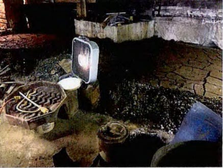 Sludge drying in basement. Note purported F006 listed hazardous waste used as berm material