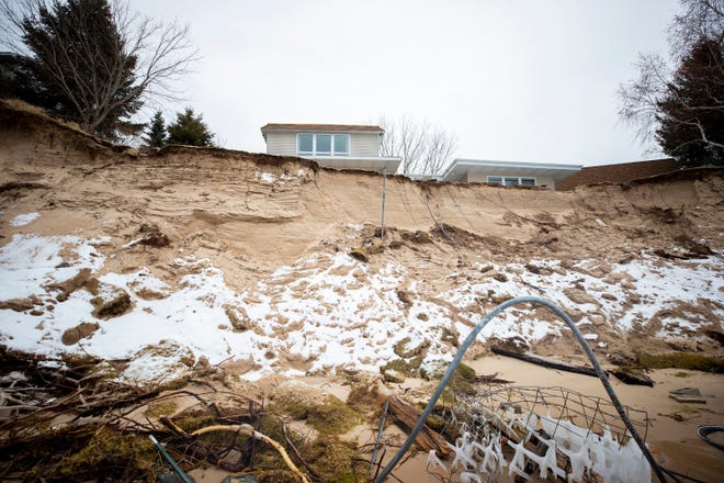 A house sits near near the edge of an eroded bluff cliff on the Lake Michigan shoreline in Shelby, Mich.