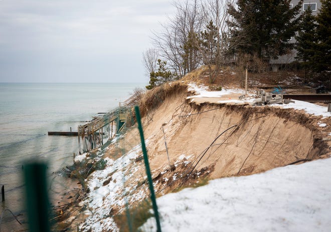 A green fence was placed at the edge of the property nearly a month ago and since then a large chunk of land has fallen into Lake Michigan in Shelby, Mich.