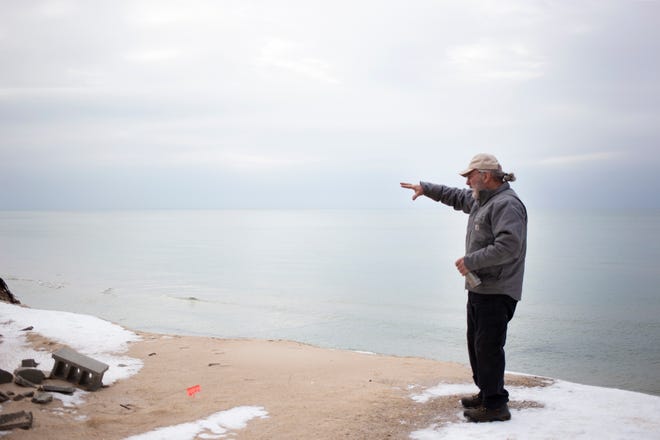 Phil Jonassen of Jonassen Inc. Structural Movers points out the erosion that has taken place since he started working to move houses in Shelby, Mich. threatened by the erosion of the Lake Michigan shoreline.