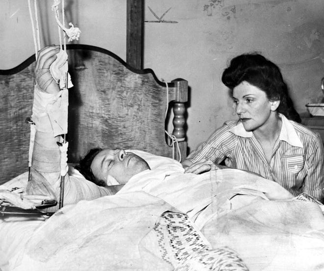 His arm in traction, a severely injured Walter Reuther lies in a bed at Grace Hospital on April 27, 1948 with his wife May at his side, after an assassination attempt that permanently damaged his right arm.