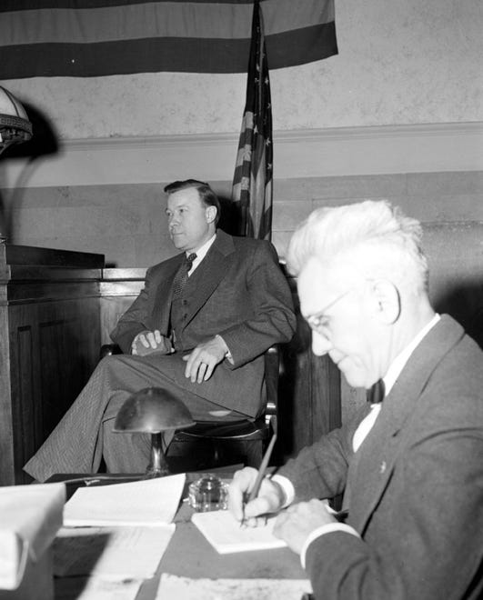 In 1950, Reuther testifies about the attempt on his life at the trial of Carl Bolton, a man charged with assault with intent to kill after two convicts said he offered them $15,000 to do the deed. Bolton was acquitted and the case was never solved. A court reporter is in the foreground.
