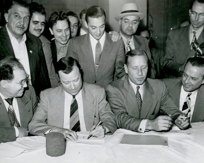 Reuther signs a contract with Ford in 1949. The young man standing behind him, William Clay Ford, who went through negotiations with Reuther, considered him an "unprincipled demagogue."