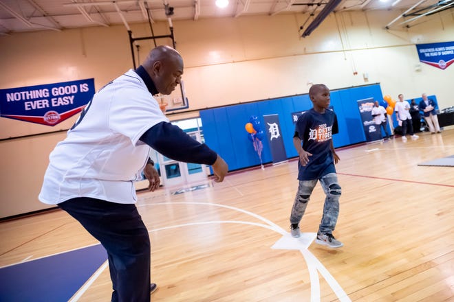 Detroit Tigers assistant hitting coach Phil Clark directs nine-year-old Kaden Snyder around a set of bases during a stop of the Detroit Tigers winter caravan at the S.A.Y. Detroit Play center in Detroit, January 23, 2020.