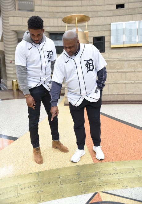 Tigers player Niko Goodrum, left, and coach Lloyd McClendon points to iconic African American figures on the ring of genealogy floor installation in the rotunda at the Charles H. Wright Museum of African American History. during a Tigers Winter Caravan stop Friday afternoon.
