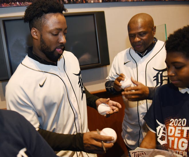 Tigers outfielder Christin Stewart, left, and coach Lloyd McClendon sign baseballs for Christian Polk, 13, of Detroit during the Tigers Winter Caravan stop at the Charles H. Wright Museum of African American in Detroit.