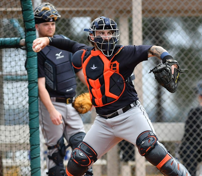 Tigers catcher Jake Rogers watches while Eric Haase, foreground, does throwing practice to different bases.