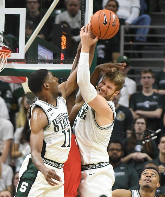 Spartans' Aaron Henry and Kyle Ahrens collide with Maryland’s Jalden Smith bringing down a rebound in the second half.