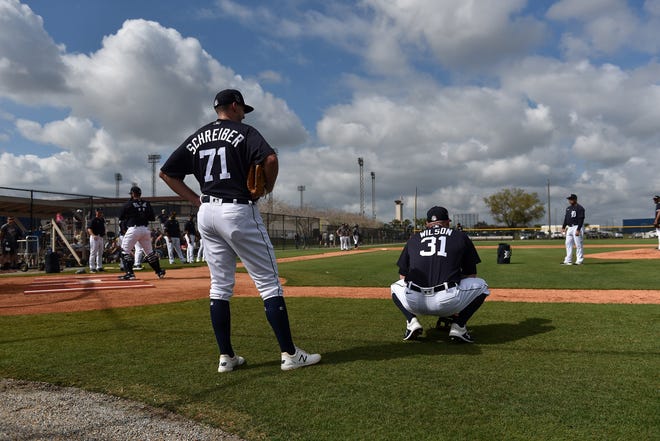 Tigers pitcher John Schreiber (71) and Alex Wilson watch during pitchers fielding practice.