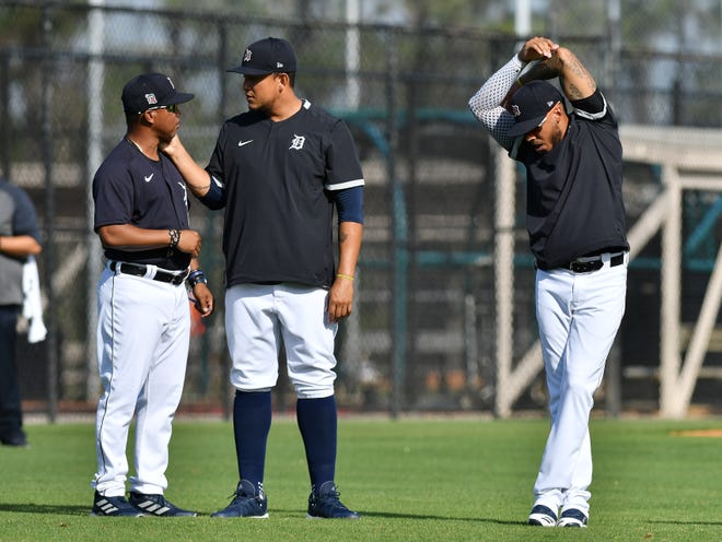 From left, Tigers third base coach Ramon Santiago talks with Miguel Cabrera while Harold Castro stretches.