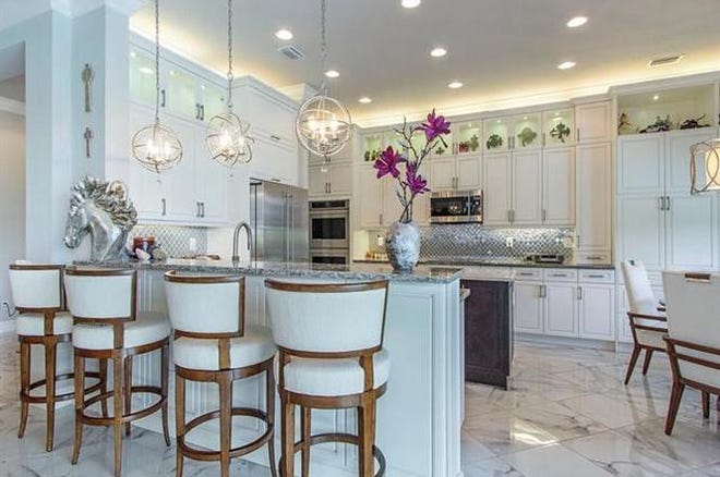 The large island kitchen features custom 42-inch cabinets, stainless appliances, including double ovens, high grade countertops and a custom backsplash.