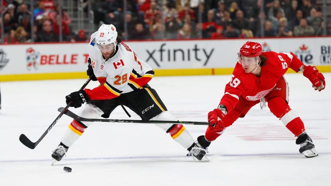 Calgary Flames center Dillon Dube (29) protects the puck from Detroit Red Wings left wing Tyler Bertuzzi (59) in the second period.