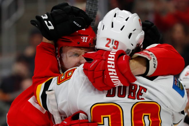 Calgary Flames center Dillon Dube (29) grabs Detroit Red Wings left wing Justin Abdelkader (8) during play in the third period.