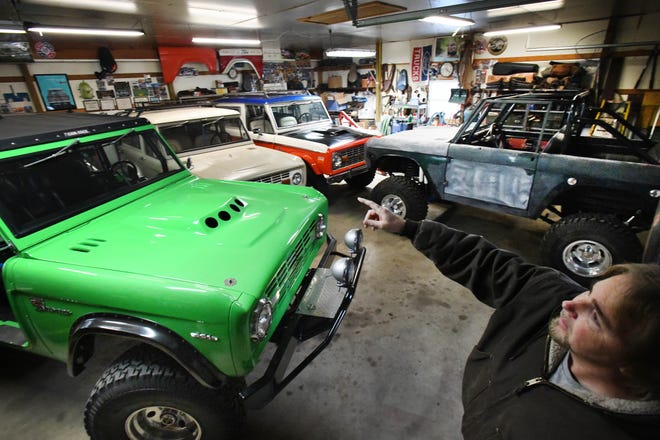 Tom Carper in one of several garages he has filled with Broncos, parts and Ford Bronco collectibles at his "Bronco Ranch."