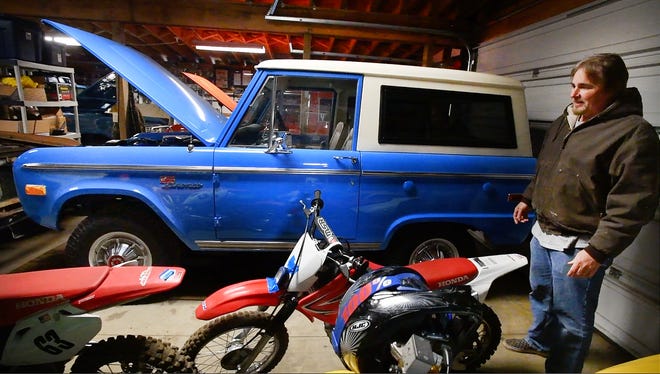 Tom Carper with a 1973 Ford Bronco he has in one of his several garages filled with Broncos, parts and collectibles, "This is a really nice stock Bronco with the first year of power steering and automatic."