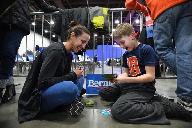 Sarah Isaksen plays 'Go Fish' with her son Gabe Isaksen, 8 ,of Birmingham as they wait for candidate Bernie Sanders to speak at at TCF Center in Detroit on Friday, March 6, 2020.