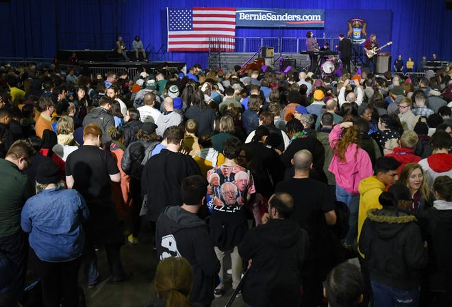 Bernie Sanders supporters, some fashionable appropriate, wait patiently for the democratic presidential candidate to take the stage.