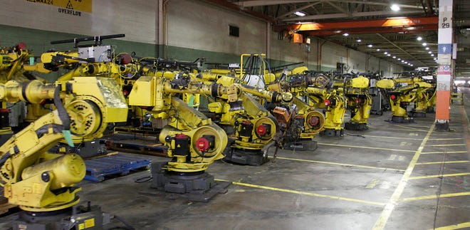 Rows and rows of robots have been removed from the assembly lines and stored inside the idle plant.