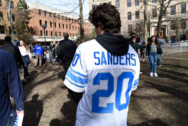 University of Michigan senior and volunteer Dominic DiFranco waits to hand out signs for U.S. Senator and presidential candidate Bernie Sanders, Sunday, March 8, 2020 in Ann Arbor, Mich.