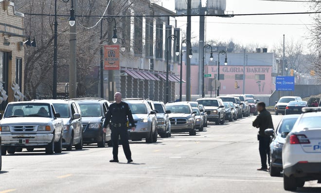 Detroit police officers direct the long line of cars for the food drive.