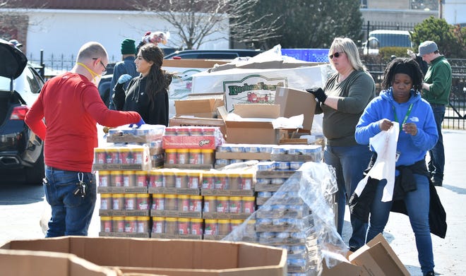From left, Tim Crandall, 39, of Detroit, Maya Hammoud, 22, of Dearborn, Annette Hoyer of Westland and Sydni Davis, 26, of Southfield load canned goods and other items into bags for pick up.