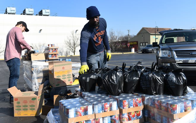 From left, Gleaners' Ryan Papiernik, 23, of Mt. Clemens and Ronnie Goodman, 46, of Detroit load bags of canned goods for people picking up.