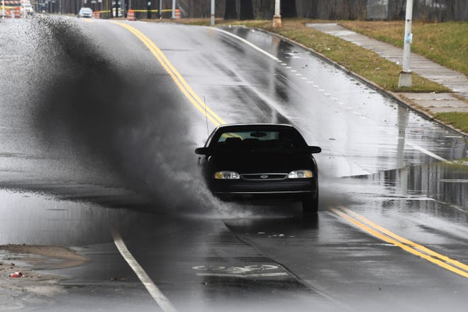 A motorist splashes through a flooded area along State Fair Avenue in Detroit on Saturday, March 28, 2020 after heavy rain.