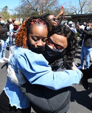 Lorenzo Seldon's wife, Renaye, left, gets a hug from sister-in-law Keisha Burnett during a memorial service Friday for Lorenzo, a union steward at Fiat Chrysler's Warren Truck plant who died of COVID-19.