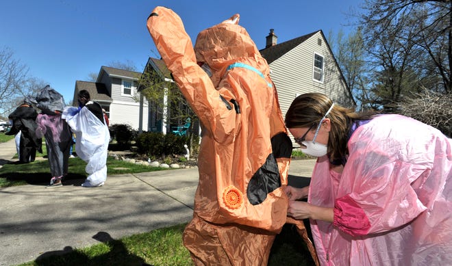 Group founder Sarah Ignash, right, helps fasten the Scooby Doo costume of Guy Krowl, both of Ferndale. Members of the Ferndale T-Rex Walking Club put on their inflatable costumes and get exercise while walking around the south end of Ferndale, Friday afternoon, May 1, 2020. All the while social distancing, they hope to bring cheer to neighbors along the route.