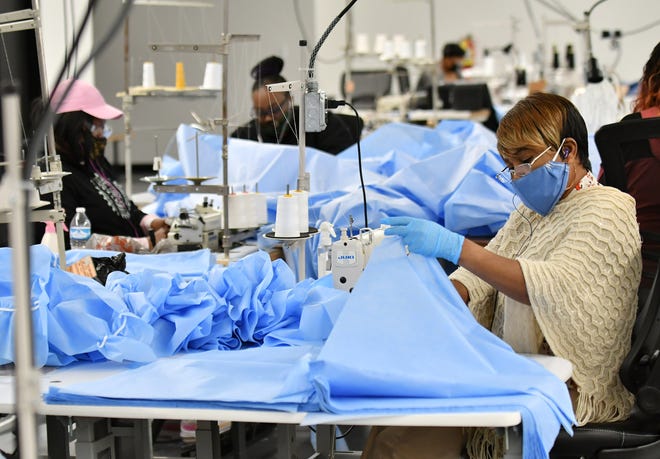 Seamstress Bernadine Kale, 57, of St. Clair Shores sews pieces of medical isolation gowns at Empowerment Plan in Detroit on May 14, 2020.