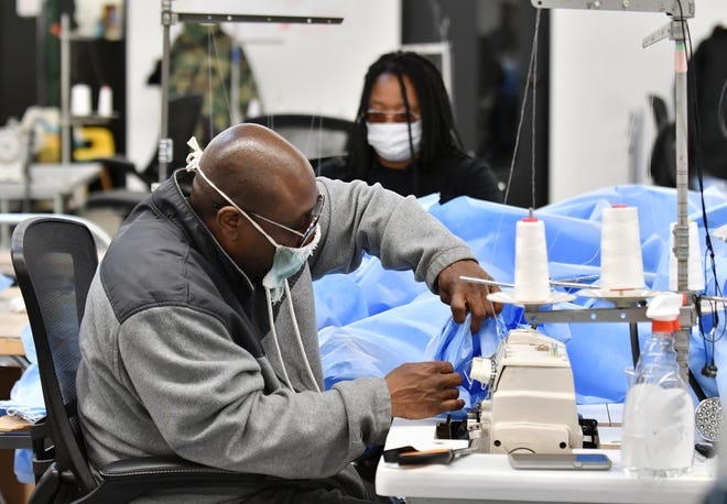 Inventory and logistics specialist Aaron Branch, 50, of Detroit sews the sleeves onto the medical isolation gowns at Empowerment Plan in Detroit on May 14, 2020.