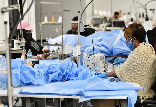 Seamstress Bernadine Kale, 57, of St. Clair Shores, right, sews pieces of medical isolation gowns at Empowerment Plan in Detroit on May 14, 2020.