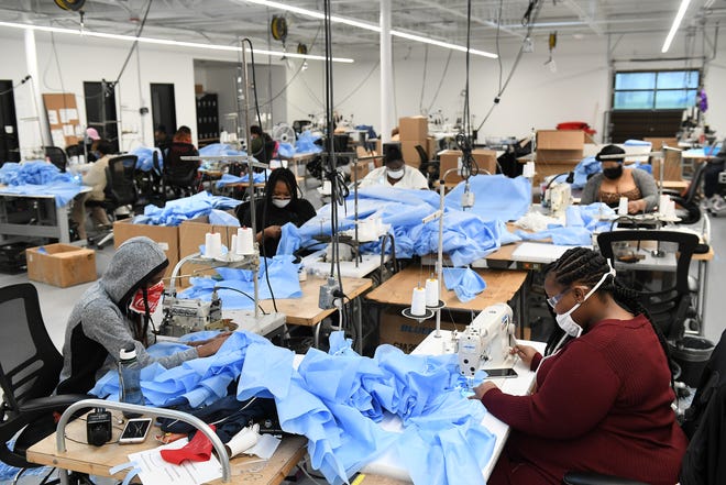 From left, Seamstresses Morgan Ealy, 25, Angel Tyler, 34, Amber Hinton, 26, Marie Dobine, 23, and Asia Taylor, 22, all of Detroit, sew medical isolation gowns at Empowerment Plan in Detroit on May 14, 2020. This crew is dedicated to producing the medical gowns while other employees will return and resume making jackets on May 18.