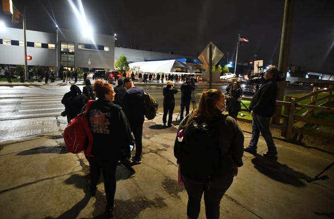 Employees wait in line at 4 am as they arrive at the employee entrance at FCA Warren Truck Assembly in Warren, Michigan on May 18, 2020.