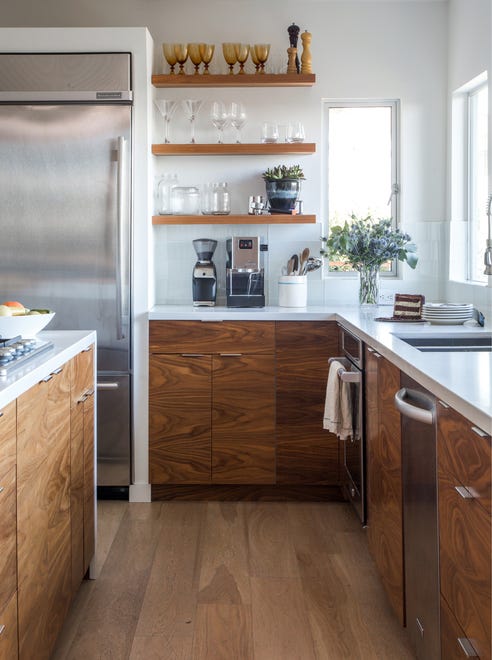 “With that much sunshine coming in we knew we could install dark wood cabinetry and shelving without the space feeling dreary,” the designers explained of this small kitchen in Los Angeles featured in the book, which boasts large windows and a nearby deck.