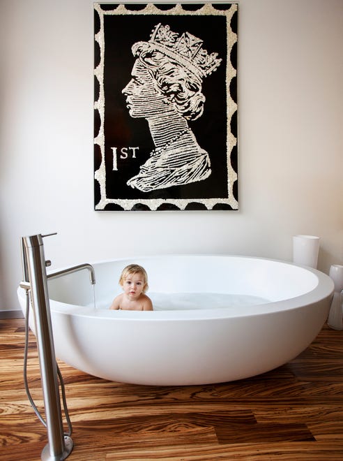 “The soapstone tub is probably the most extravagant fixture we’ve ever purchased for a home,” they claim of the piece. The art work is "The Queen" by Ann Carrington.