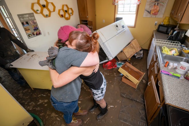 Rebecca Johnson, right, hugs her niece, Paige Benjamin, as Johnson cleans out the kitchen of her home in Sanford on Thursday. Sanford was hit especially hard after the Sanford dam failed earlier in the week.