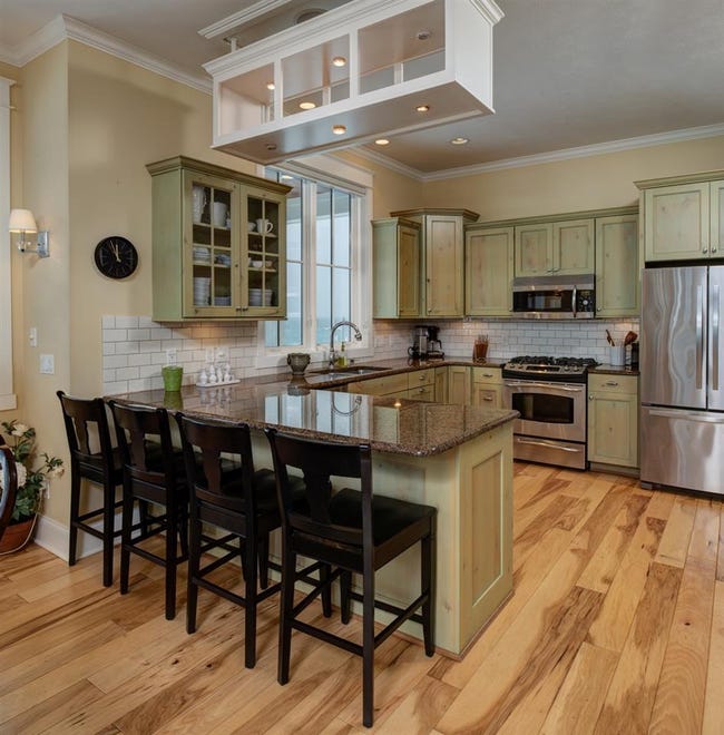 The kitchen features built in microwave, stainless appliances and seating area.