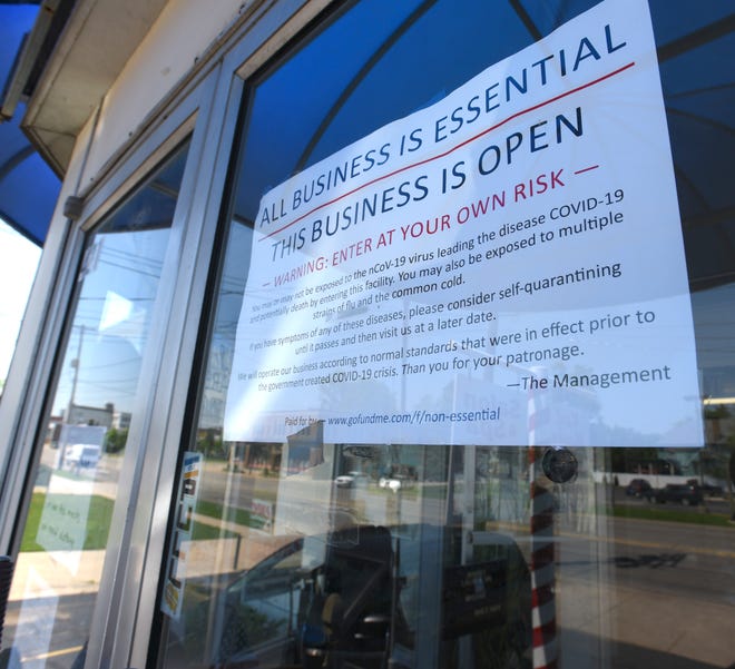 A sign in the window of Karl Manke ' s barber shop proclaiming all business is essential, Tuesday, June 2, 2020. Manke keeps his Owosso barber shop open even though Governor Gretchen Whitmer ordered non-essential businesses to close during the COVID-19 lockdown.