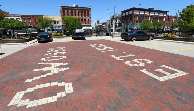 Bricks on the sidewalk in a public parking lot in downtown Owosso that was established in 1836.