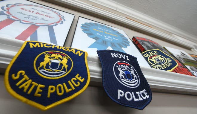 Michigan State Police, Novi Police and Chesterfield Twp. police shoulder patches are displayed at the barbershop.