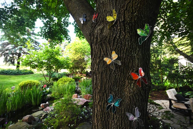 Butterflies work their up a tree trunk, a tribute to Kathy ' s deceased parents.
