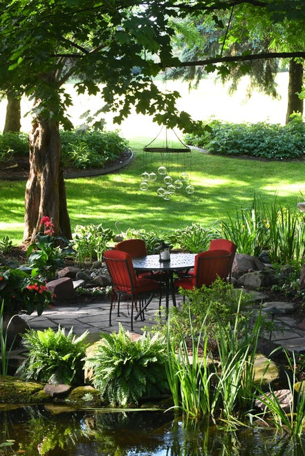 Flagstone weaves its way through Steven and Kathy Braykovich ' s backyard in Pinckney. Pictured is one of four seating areas.